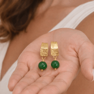 brincos de aventurina banhados a ouro 18k.na palma da mãos da modelo