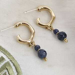 Brincos de Meia Argola com Safira Facetada Folheados a Ouro 18k ✨ Peça única, feita à mão e exclusiva da Ceci Joias ✨ Os brincos de meia argola com safira facetada folheados a ouro 18k são verdadeiras joias artesanais criadas para mulheres que apreciam elegância, sofisticação e exclusividade.