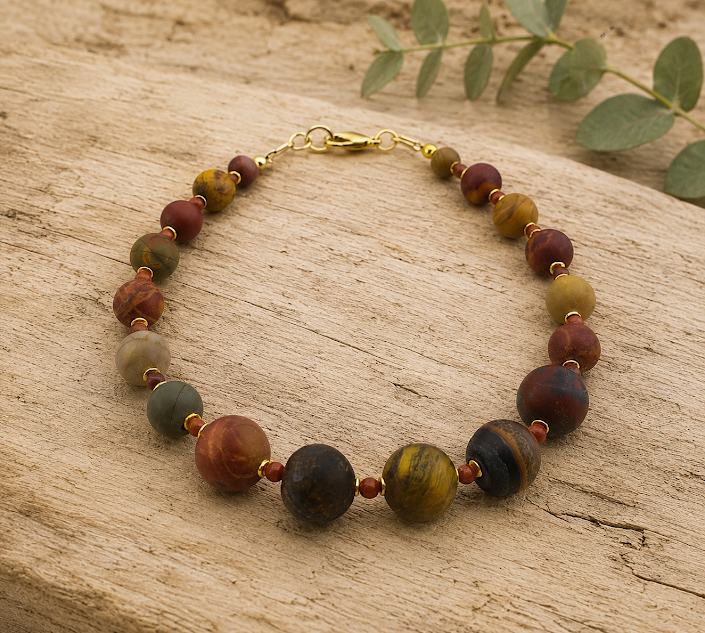 pulseira jaspe picasso e jaspe vermelho , feita à mão, pela ceci joias da amazonia. Semijoia sobre a madeira rustica