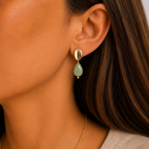 brincos jade gota, banhado a ouro 18k, no lobulo da modelo.