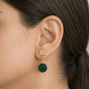 brincos de aventurina facetada, base banhada a ouro 18k, no lobulo da modelo