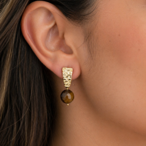 brincos olho de tigre 10 mm banhados a ouro 18k. feitos a mão pela Ceci joias. Lobulo da modelo