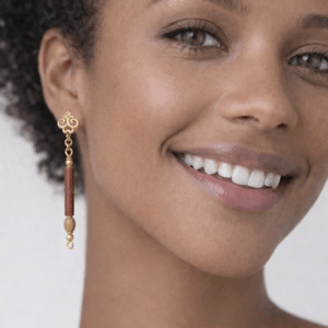 brincos de ceramica e madeira, banhados a ouro 18k. No lobulo da modelo.