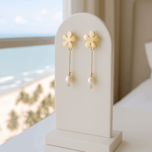 Brincos de pérola e flor folheados a ouro 18k exibidos em suporte elegante Ceci Joias"