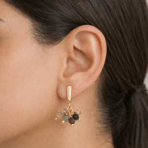 brincos agata indiana cachinho banhados a ouro 18k no lobulo da modelo
