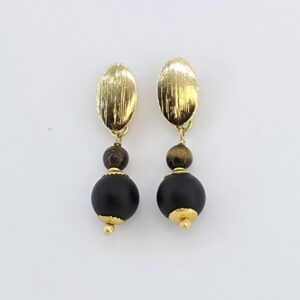 Brincos de Ônix Fosco e Olho de Tigre Folheados a Ouro 18k Os Brincos de Ônix Fosco e Olho de Tigre Folheados a Ouro 18k são joias artesanais exclusivas que combinam a força e o charme das pedras naturais em um design sofisticado e atemporal. Feitos à mão com atenção aos mínimos detalhes, são perfeitos para quem busca elegância, autenticidade e durabilidade em uma semijoia.