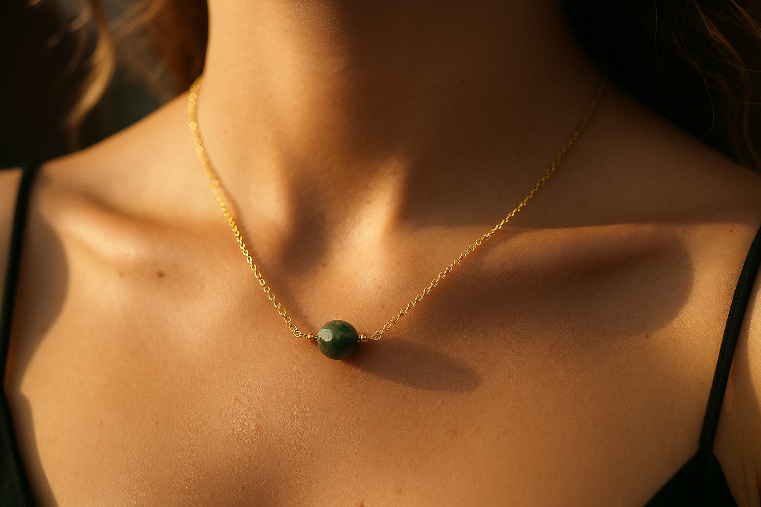 Colar elo português com ágata indiana de 8 mm folheado a ouro 18k no colo de uma mulher, luz de fim de tarde