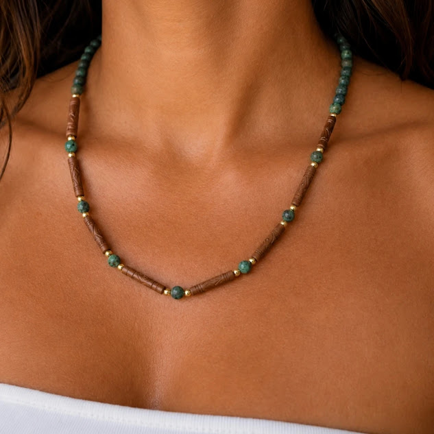 colar de turquesa africana fosca, cerâmica feita a mão, entremeios e fechos banhados a ouro 18 k, no colo da modelo.
