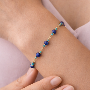 Pulseira lapis lazuli e turques banhado a ouro 18k no punho da modelo.