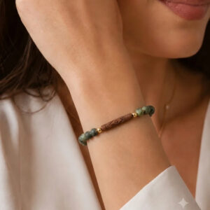 Pulseira turquesa africana fosca com detalhe en ceramica, entremeios banhados a ouro 18k. no punho da modelo.