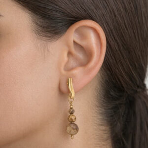 brincos de jaspe picture banhado a ouro 18 k. exposto no lobulo da modelo