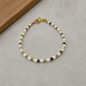pulseira de pedra da lua e turmalina melancia banho de ouro 18k. fundo de cimento queimado