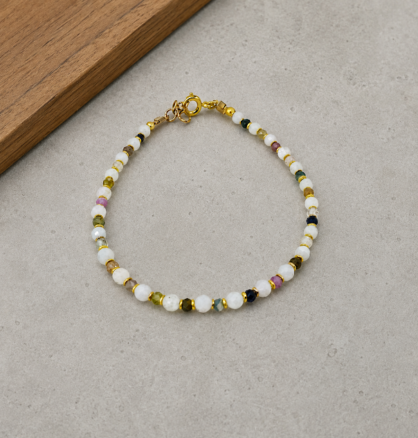 pulseira de pedra da lua e turmalina melancia banho de ouro 18k. fundo de cimento queimado