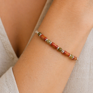 pulseira madeira e granada verde no pulso da modelo.