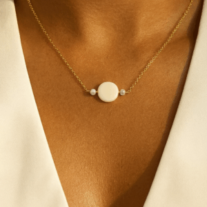 mulher elegante usando colar artesanal de madrepérola com corrente elo português banhada a ouro 18k – biojoia delicada e exclusiva da Ceci Joias da Amazônia.
