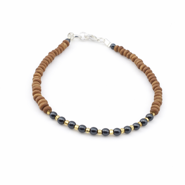 Pulseira de Madeira e Hematita e citrino Banhada a Ouro 18k — Elegância Natural em Cada Detalhe A Pulseira de Madeira e Hematita Banhada a Ouro 18k é uma biojoia artesanal exclusiva da Ceci Joias da Amazônia, criada à mão com materiais naturais selecionados e acabamento fino em 10 milésimos de ouro 18k. Com 20 cm de comprimento, esta pulseira delicada combina a textura orgânica da madeira com o brilho metálico da hematita, resultando em uma peça leve, sofisticada e cheia de personalidade. fundo branco.