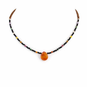 colar de ônix e pedras brasileiras de 2 mm com detalhes em sândalo e pingente de gota laranja, exibido em suporte branco de exposição