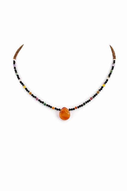 colar de ônix e pedras brasileiras de 2 mm com detalhes em sândalo e pingente de gota laranja, exibido em suporte branco de exposição colar de ônix e pedras brasileiras de 2 mm com detalhes em sândalo e pingente de gota laranja, exibido em suporte branco de exposição