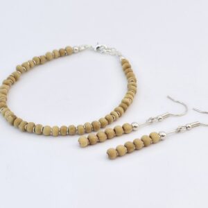 Conjunto de brincos e pulseira de madeira branca com detalhes banhados a prata 925 sobre fundo branco, joias artesanais exclusivas da Ceci Joias da Amazônia.