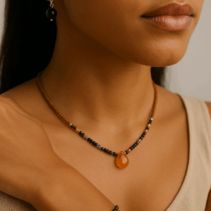modelo morena usando conjunto artesanal com colar de pingente laranja, pulseira e brincos de ônix e pedras brasileiras de 2 mm, joias com contas de sândalo e banho de prata