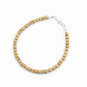 Pulseira de madeira branca com entremeios em prata 925 no punho feminino, joia artesanal delicada e sofisticada da Ceci Joias da Amazônia.