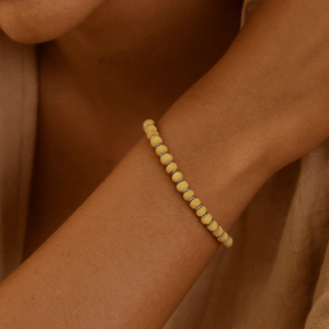 Pulseira de madeira branca com entremeios em prata 925 no punho feminino, joia artesanal delicada e sofisticada da Ceci Joias da Amazônia.