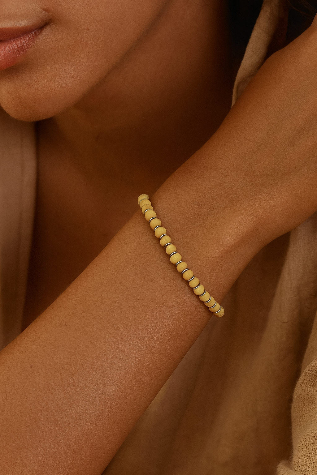 Pulseira de madeira branca com entremeios em prata 925 no punho feminino, joia artesanal delicada e sofisticada da Ceci Joias da Amazônia.