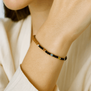 pulseira artesanal de ônix e pedras brasileiras de 2 mm com detalhes em sândalo no punho feminino, joia delicada e colorida