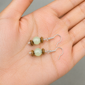 brincos de jade e madeira na palma da mão da modelo, feitos pelamCeci joias em Belém do Pará.
