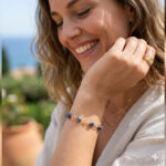 Pulseira de sodalita fosca com banho de ouro 18 k. no punho da modelo.