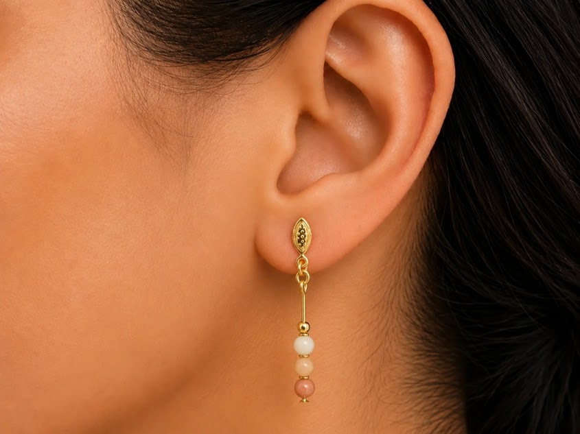 Mulher usando brinco pendente de aventurina pêssego e ouro 18k, demonstrando o tamanho e a leveza de 3,5 cm Imagem 3 (fundo branco):
